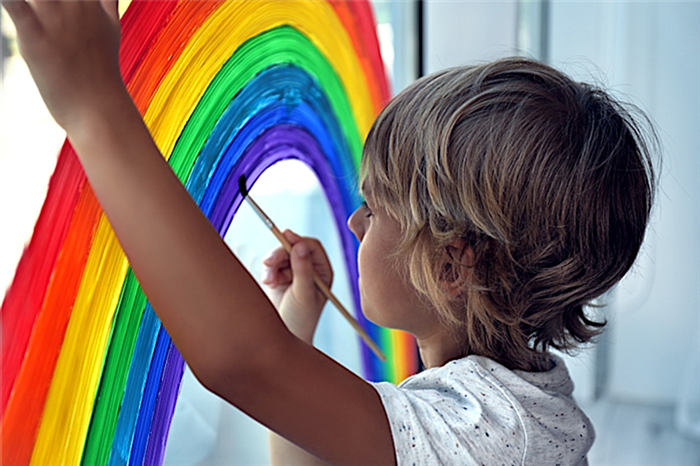 Ребенок использует темперную краску на стекле